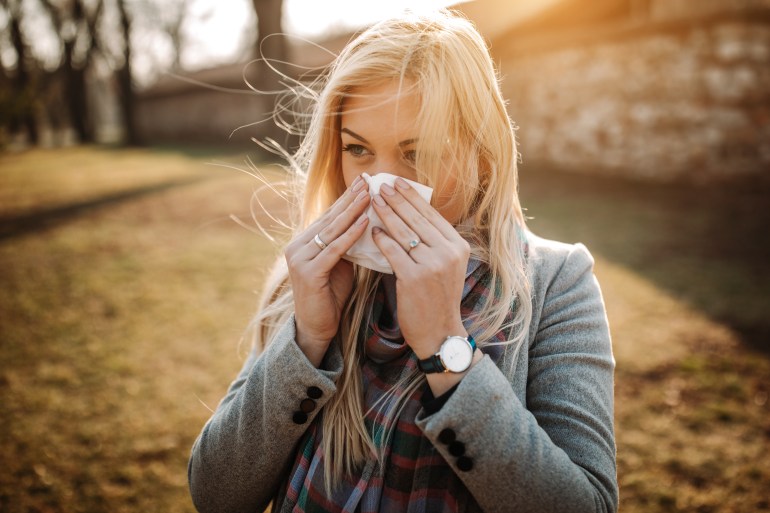 Sick blonde blowing her nose