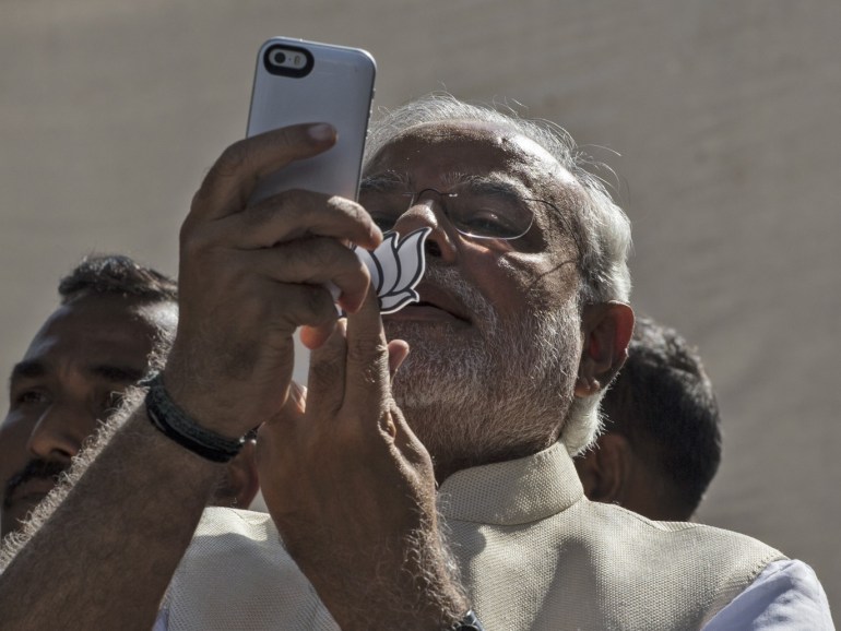 AHMEDABAD, INDIA - APRIL 30: BJP leader Narendra Modi takes a picture of himslef, his inked finger and the party insignia with his mobile phone after voting at a polling station on April 30, 2014 in Ahmedabad, India. India is in the midst of a nine-phase election that started on April 7 and ends May 12. (Photo by Kevin Frayer/Getty Images)