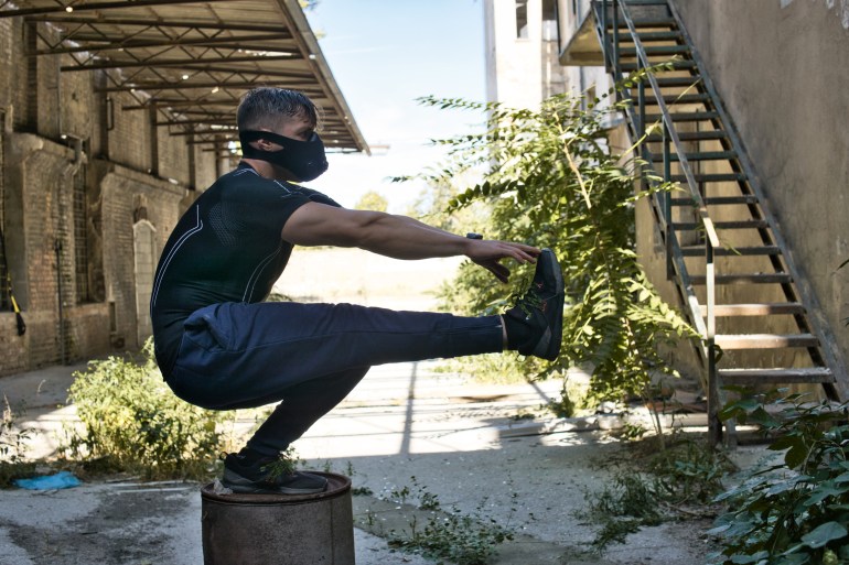 قُرفصاء المسدس.. تمرين حاسم لتقييم لياقتك البدنية Muscular man standing with one leg on bin.