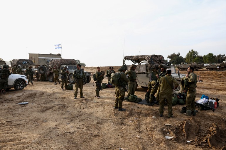 Israeli soldiers stand near the border with the Gaza Strip, amid the ongoing conflict between Israel and the Palestinian Islamist group Hamas, in Beeri, Israel, December 8, 2023. REUTERS/Athit Perawongmetha