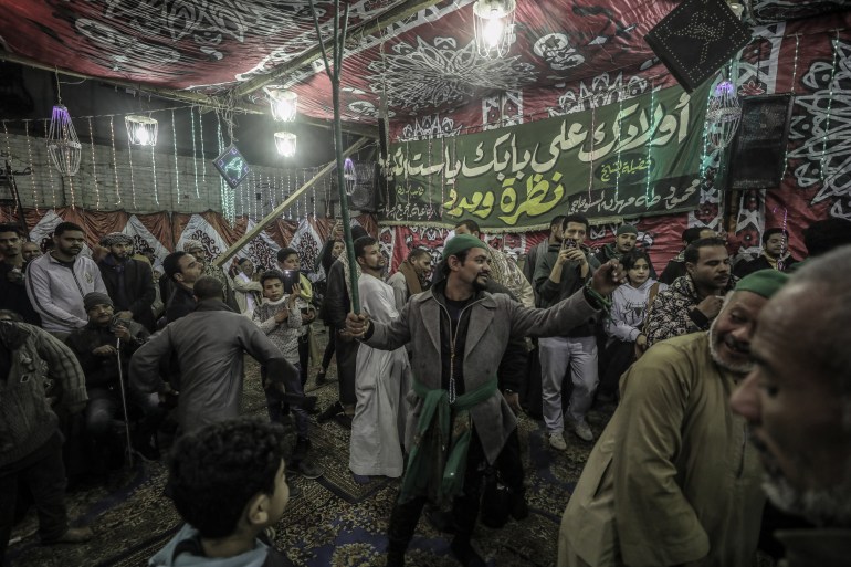 صوت المدائح والتواشيح لا تتوقف في محيط مسجد "السيدة زينب"، في حي شهير يحمل ذات الاسم وسط القاهرة، وتذوب عشقا بين حشود كبيرة تتمايل وتنطق بعبارات في حب النبي محمد (ص) وآل بيته. تلك الأجواء والطقوس الصوفية التراثية، تعرفها مصر في الثلاثاء الأخير من شهر "رجب" بالتقويم الهجري من كل عام، احتفاء بالليلة الختامية لـ "مولد السيدة زينب"، أحد أكبر وأشهر مساجد القاهرة، والذي ينسب إلى حفيدة النبي زينب بنت علي بن أبي طالب. ( Mohamed Elshahed - وكالة الأناضول )