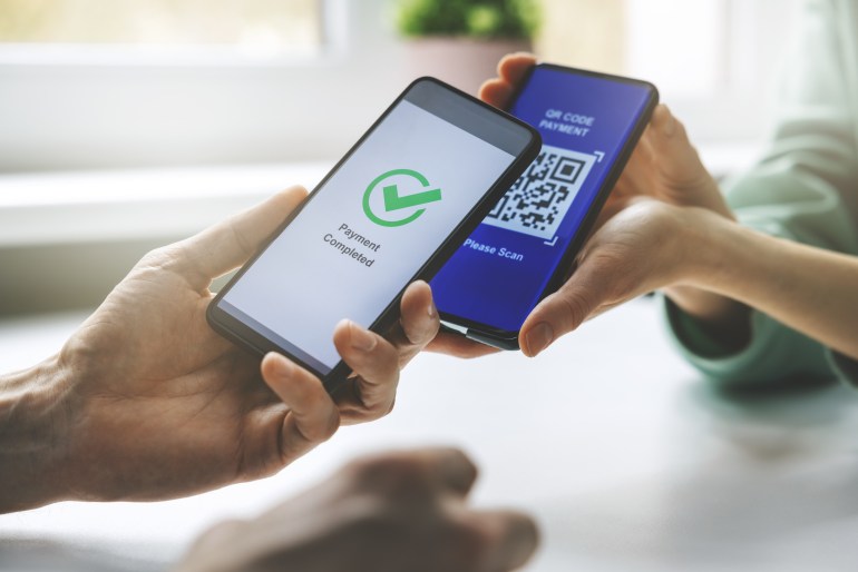 qr code payment - person paying with mobile phone shutterstock_1931626895