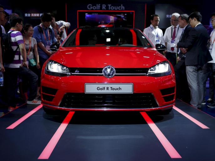 Attendees look at a Volkswagen Golf R Touch car during the 2015 International Consumer Electronics Show Asia in Shanghai, in this May 25, 2015 file picture. Automakers' latest projections for rapid growth of China's green car market have added to concerns of worsening smog as the uptake of electric vehicles powered by coal-fired grids races ahead of a switch to cleaner energy. REUTERS/Aly Song/Files