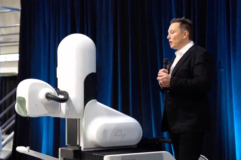 This video grab made from the online Neuralink livestream shows Elon Musk standing next to the surgical robot during his Neuralink presentation on August 28, 2020. Futurist entrepreneur Elon Musk late August 28 demonstrated progress made by his Neuralink startup in meshing brains with computers, saying the work is vital to the future of humanity. (Photo by Neuralink / AFP) / RESTRICTED TO EDITORIAL USE - MANDATORY CREDIT "AFP PHOTO / NEURALINK " - NO MARKETING - NO ADVERTISING CAMPAIGNS - DISTRIBUTED AS A SERVICE TO CLIENTS