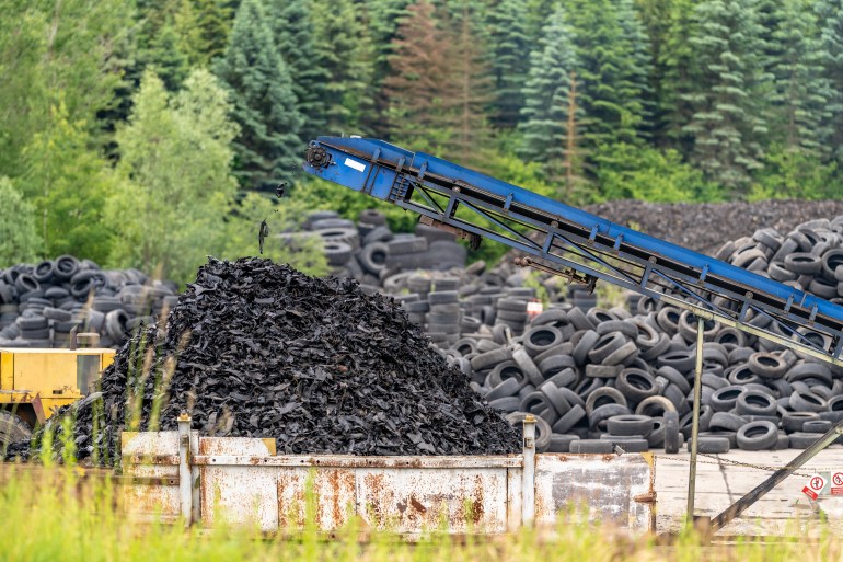 recycling and processing of old tires, crushed rubber go on a conveyor belt to a container; Shutterstock ID 2318423597; purchase_order: AJA; job: ; client: ; other: