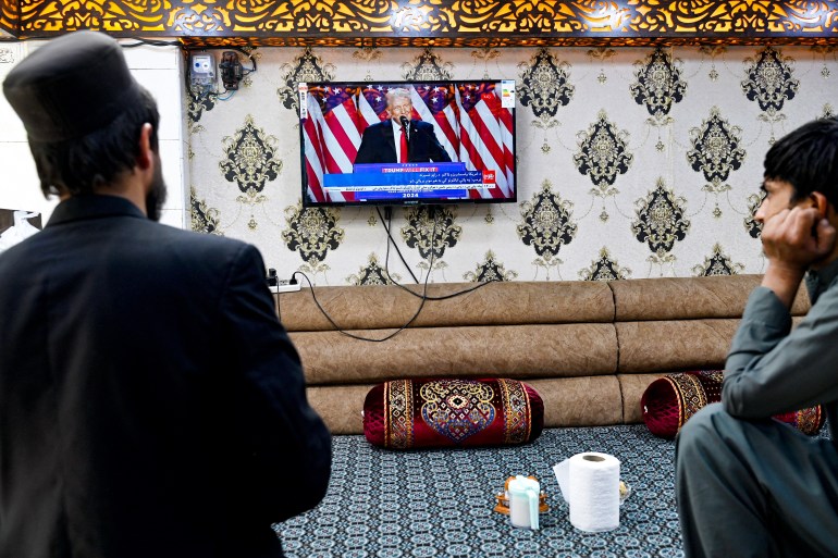 Afghan men watch a television broadcast of Tolo News channel at a restaurant in Kabul on November 6, 2024, featuring US former president and Republican presidential candidate Donald Trump as he addresses an election night event at Florida. (Photo by Wakil KOHSAR / AFP)