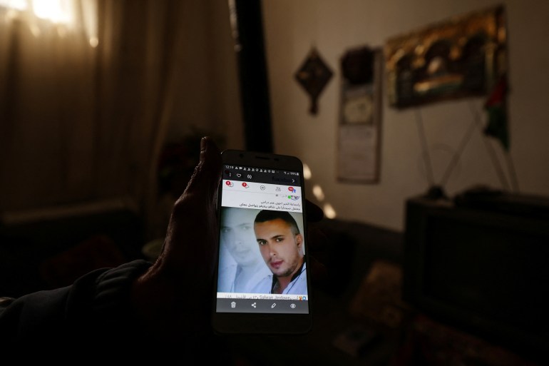 Ibrahim Daraji, who said he is still mourning two sons, one disappeared into Sednaya prison and another lost to a mortar strike in Al-Yarmouk camp, shows a photo of his son Omar on his phone at his house at al-Yarmouk Palestinian refugee camp, after fighters of the ruling Syrian body ousted Bashar al-Assad, in Damascus, Syria December 20, 2024. REUTERS/Zohra Bensemra