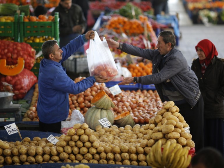 A vendor sells potatoes and other vegetables to a customer in an open market in central Ankara February 5, 2014. The humble potato has become a factor in Turkey's political and economic turmoil as prices of the staple soar, hurting the living standards of poorer Turks just before the ruling AK Party's toughest election test in a decade. At a market in the lower-income Istanbul suburb of Kucukcekmece, potatoes sell for between 3 and 4 lira ($1.33 and $1.77) a kilogram, up from slightly more than 1 lira at about this time last year. REUTERS/Umit Bektas (TURKEY - Tags: POLITICS BUSINESS FOOD)