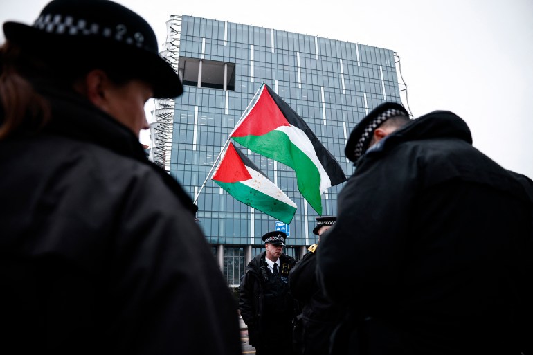 Palestinian flags flap in the aire as police officers stand guard in front of the US embassy during a Pro-Palestinian march in central London, on February 15, 2025, organised by the Palestine Solidarity Campaign. Demonstrators gathered in London on February 15 to march from Whitehall to the US Embassy in what is expected to be one of the largest shows of solidarity for Palestinians. (Photo by BENJAMIN CREMEL / AFP)