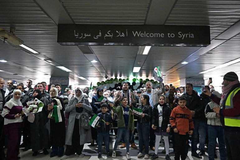 People wait to welcome travellers at the Damascus International Airport on January 7, 2025. Syria's main airport in Damascus will resume international flights starting January 7 after such commercial trips were halted following last month's ousting of president Bashar al-Assad. (Photo by LOUAI BESHARA / AFP)