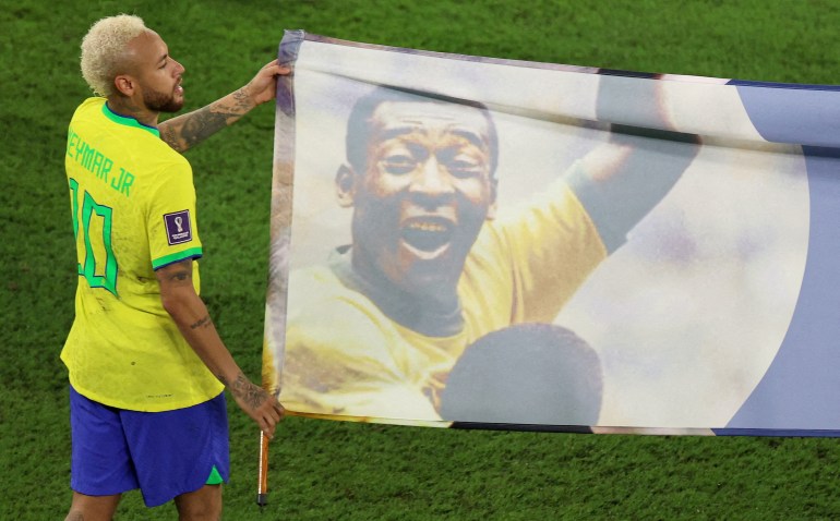 FILE PHOTO: Soccer Football - FIFA World Cup Qatar 2022 - Round of 16 - Brazil v South Korea - Stadium 974, Doha, Qatar - December 5, 2022 Brazil's Neymar carries a banner of former Brazil player Pele after the match REUTERS/Pedro Nunes/File Photo