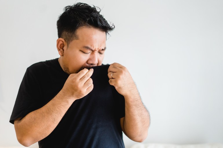 Asian Man body with sweat on black t shirt workout fit from home.bad smell breathing on armpit with black shirt.indian man smelly.hyperhidrosis, deodorant, Medical health.Men Skin body care.