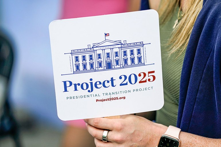 Kristen Eichamer holds a Project 2025 fan in the group's tent at the Iowa State Fair, on August 14, 2023, in Des Moines, Iowa. A constellation of conservative organizations is preparing for a possible second White House term for Donald Trump. The Project 2025 effort is being led by the Heritage Foundation think tank [Charlie Neibergall/AP Photo]