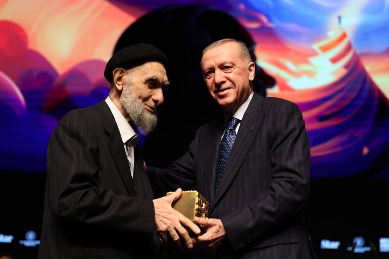 ISTANBUL, TURKIYE - JANUARY 03: (----EDITORIAL USE ONLY - MANDATORY CREDIT - 'TURKISH PRESIDENCY / MURAT KULA / HANDOUT' - NO MARKETING NO ADVERTISING CAMPAIGNS - DISTRIBUTED AS A SERVICE TO CLIENTS----) Turkish President Recep Tayyip Erdogan (L) presents Necip Fazil Poetry Award to Hasan Celebi during the Necip Fazil Awards ceremony at Ataturk Cultural Center in Istanbul, Turkiye on January 03, 2025. ( TUR Presidency/ Murat Kula - Anadolu Agency )