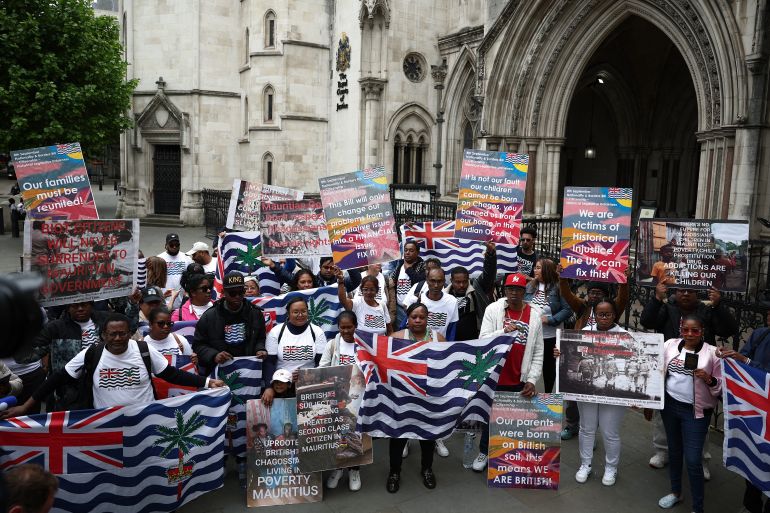 Members of the Chagossian community and supporters pose for a photo outside the High Court in London on May 22, 2025, as a hearing into the fate of the Chagos Islands, goes on inside.