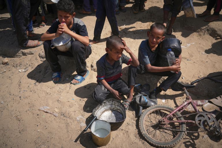 Palestinian children wait to get donated food at a community kitchen in Khan Younis, in the southern Gaza Strip, Friday, May 9, 2025. (AP Photo/Abdel Kareem Hana)