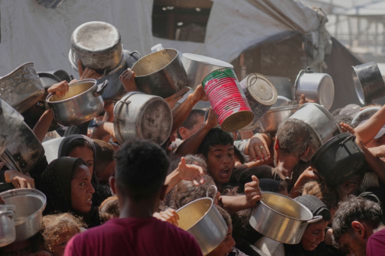 Palestinians struggle to obtain donated food at a community kitchen in Khan Younis, in the southern Gaza Strip, Friday, May 9, 2025. (AP Photo/Abdel Kareem Hana)