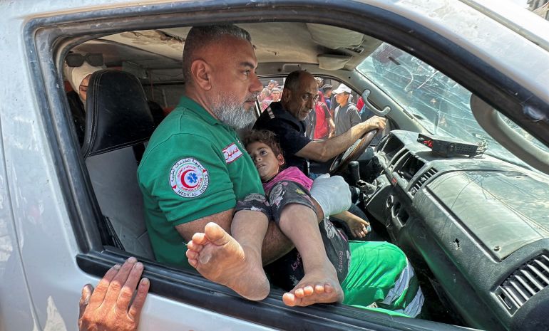 A man carries a girl as Palestinians evacuate the wounded from the site of an Israeli airstrike in Gaza City, according to medics, June 5, 2025. REUTERS/Khamis Al-Rifi BEST QUALITY AVAILABLE.