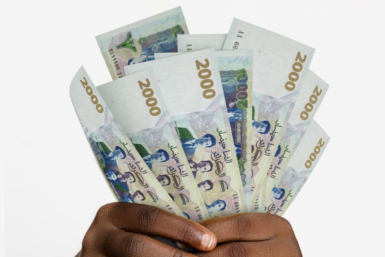 Black hands holding 3D rendered 2000 Algerian Dinar notes. closeup of Hands holding Algerian currency notes