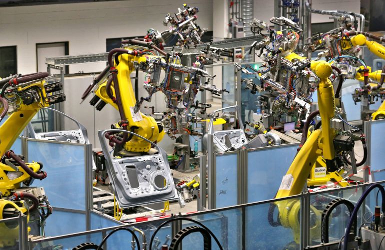 مصنع سيارة بورش - روبوت - ألمانيا View of production robots at the door production line of the new car body manufacture of sports car manufacturer Porsche in Leipzig, Germany, 13 March 2013. The small SUV Macan is planned to become the third Porsche model produced in Leipzig towards the end of the year. In the biggest construction project in Porsche's history the plant in Leipzig is currently being expanded for 500 million euros. Porsche is also currently looking for 1,000 new employees for the enlarged plant. Photo: JAN WOITAS | usage worldwide (Photo by Jan Woitas/picture alliance via Getty Images)