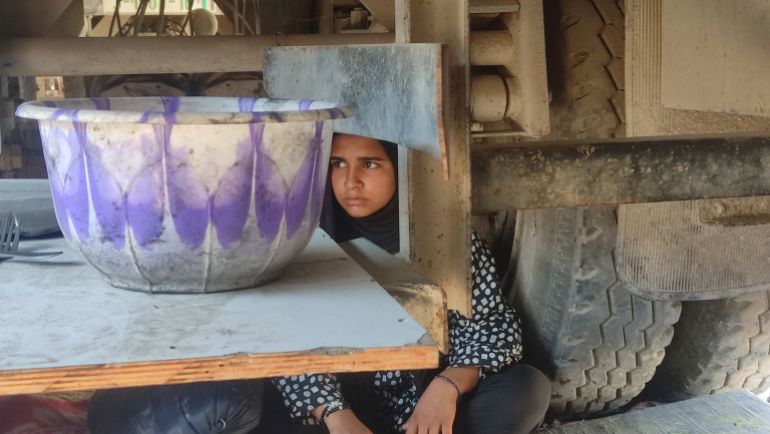 هذه الصورة واحدة من أقسى مشاهد النزوح والمعاناة في غزة، حيث تظهر فتاة صغيرة تجلس تحت شاحنة، في محاولة للاتقاء من حر الشمس أو احتماءً من خطر القصف